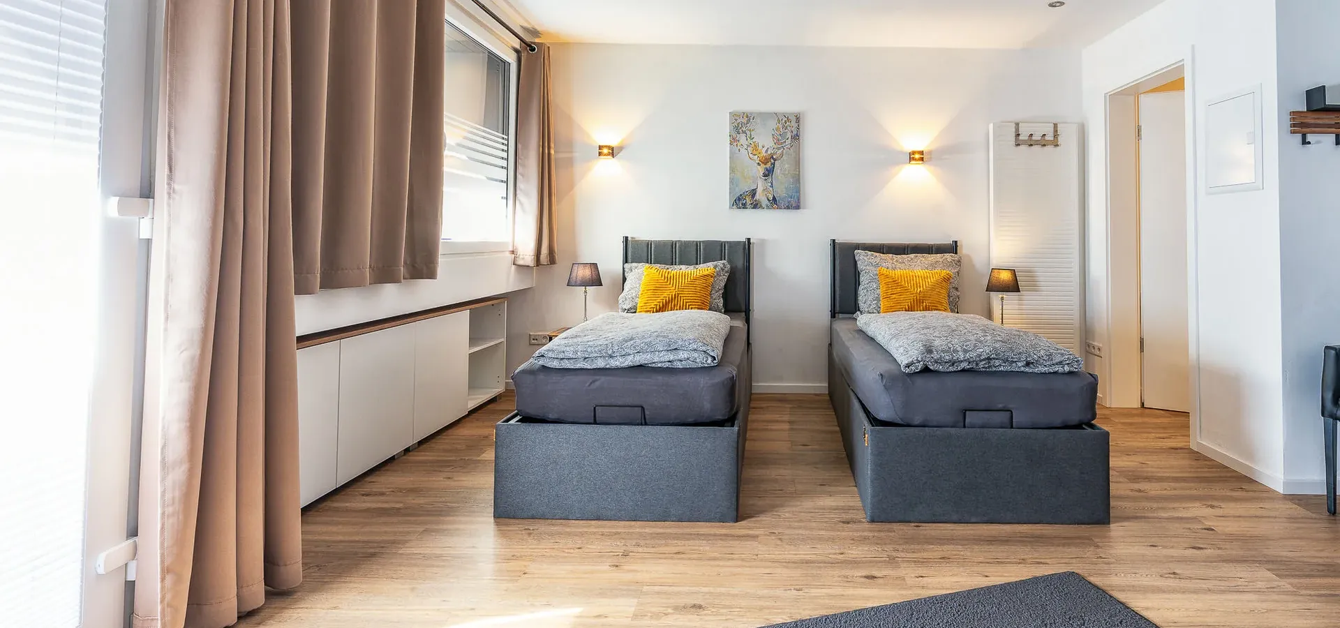 Helles Schlafzimmer mit zwei Betten und Vorhängen