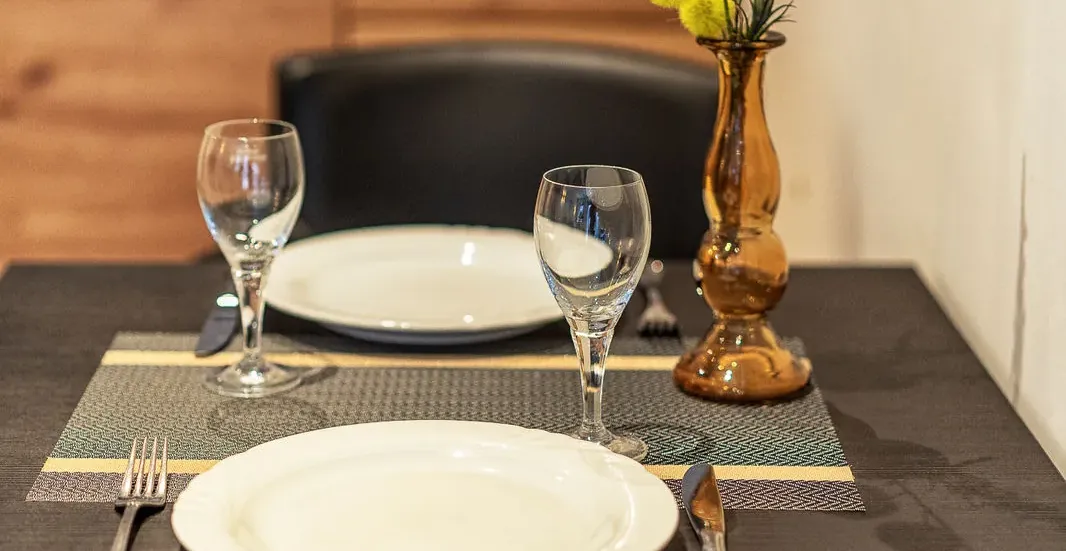 Gedeckter Esstisch mit Gläsern und Vase