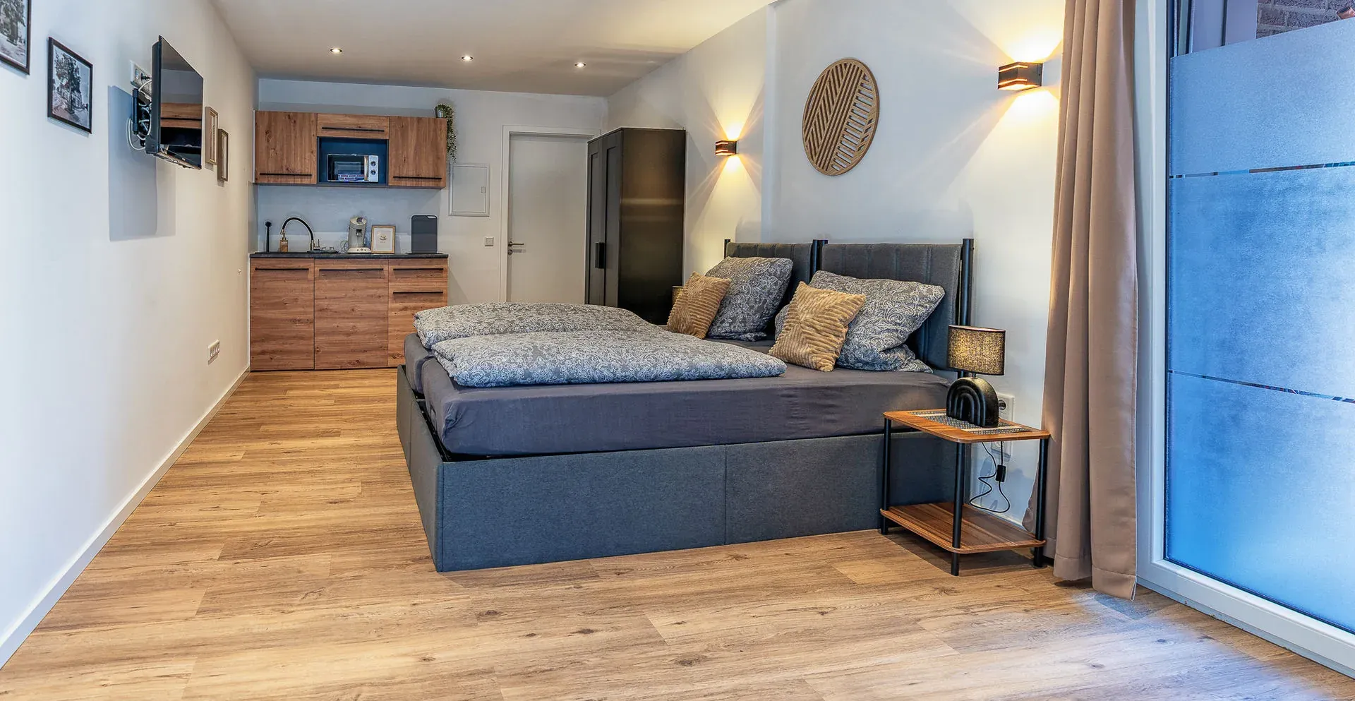 Lichte woonruimte met keukenblok en bedden in appartement 3