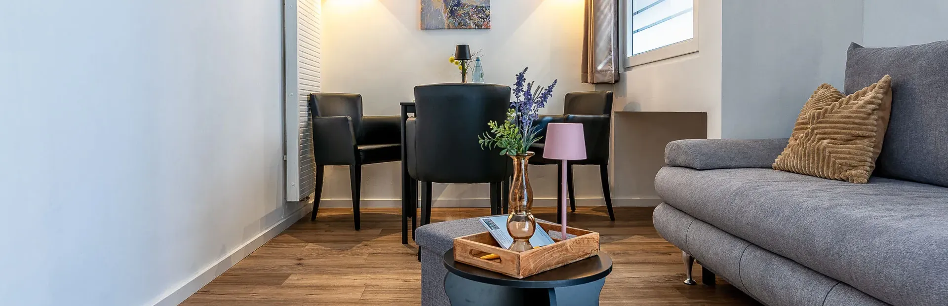 Blick in den Wohnbereich mit grauem Sofa
