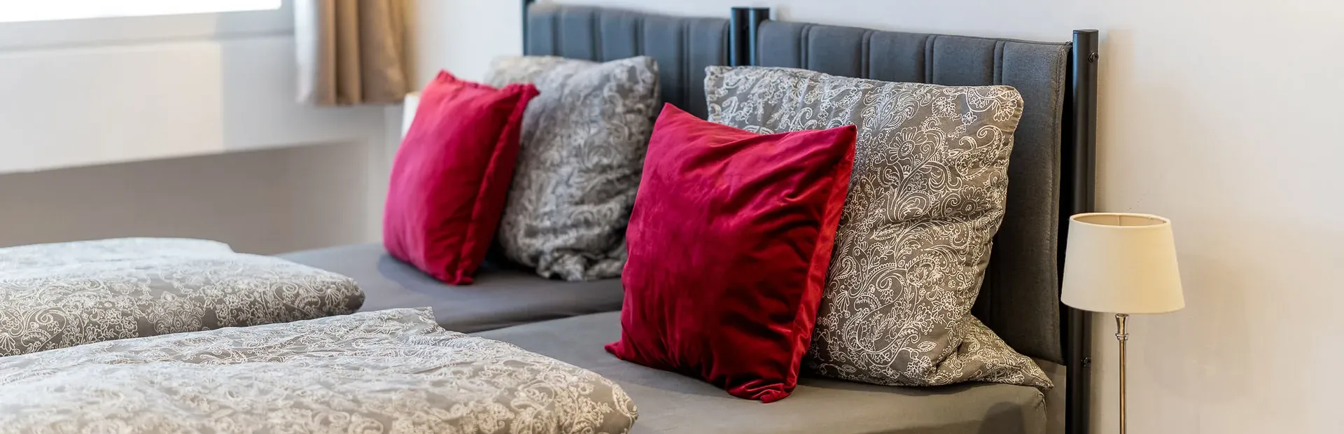 Bett mit Kissen und Nachttischleuchte