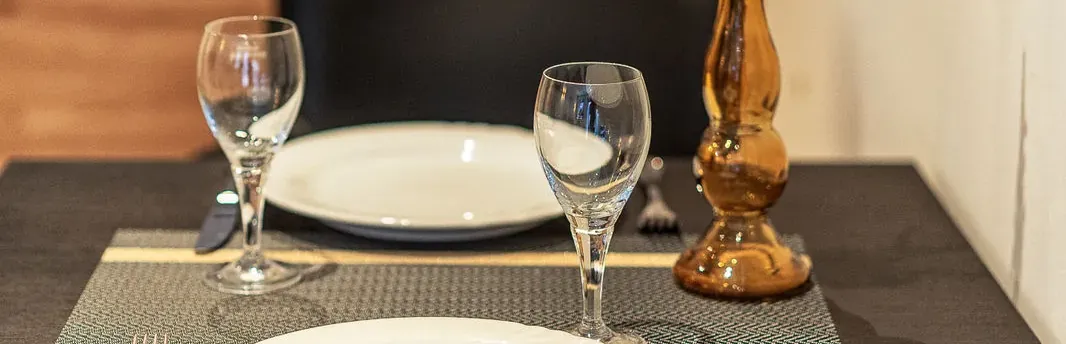 Gedeckter Esstisch mit Gläsern und Vase