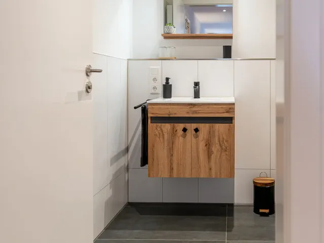 Badezimmer mit Waschtisch und ebenerdiger Dusche