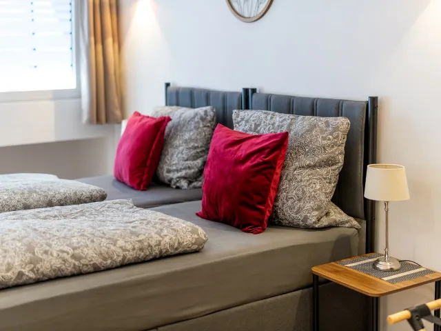 Bett mit Kissen und Nachttischleuchte