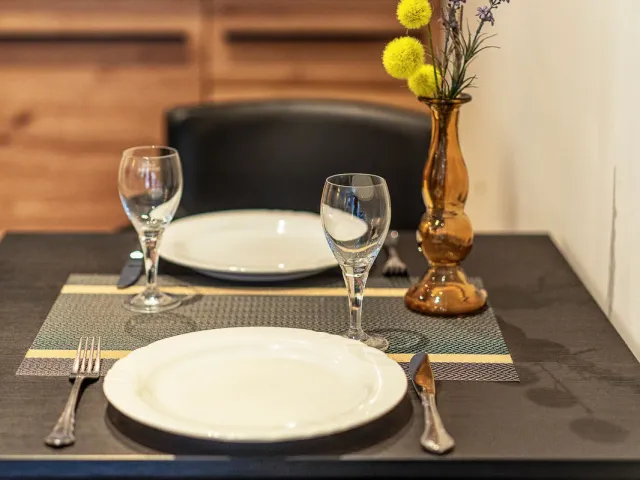 Gedeckter Esstisch mit Gläsern und Vase