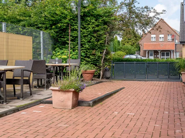 Terrasse mit Sitzgelegenheiten und Grünanlage